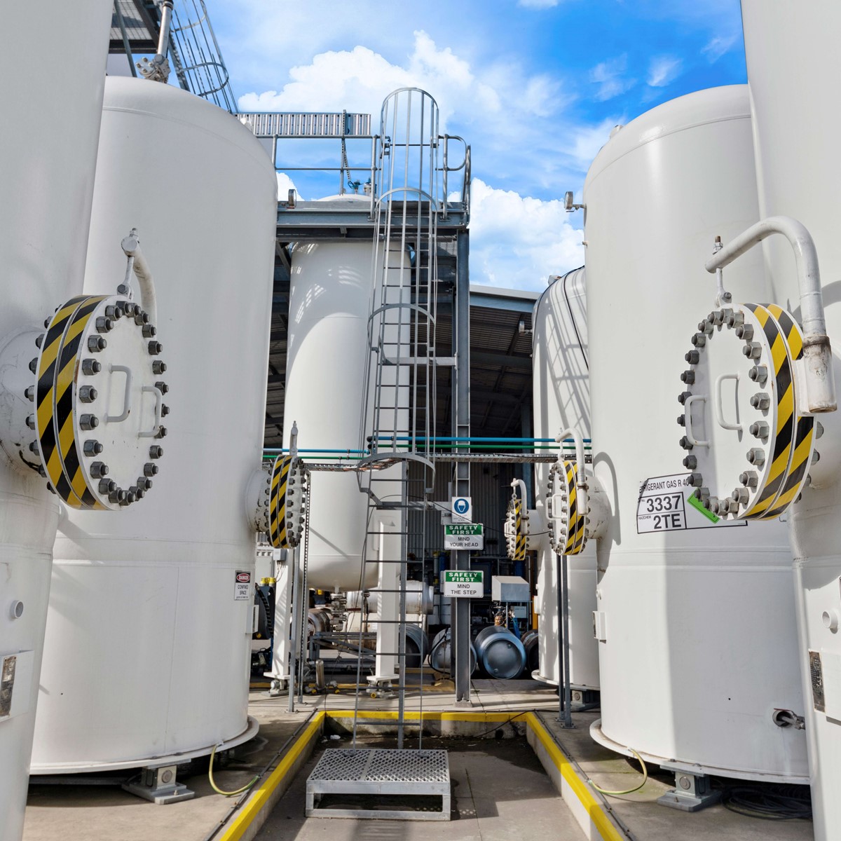 Close-up of four white separation tanks in an outside yard