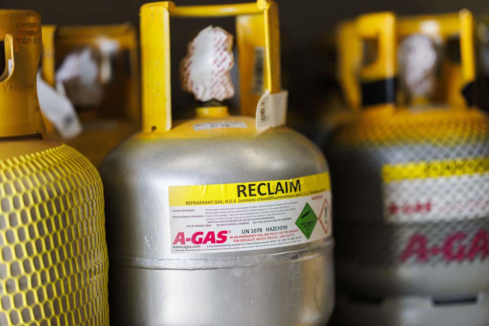 Close up of yellow and silver gas cylinder with Reclaim label