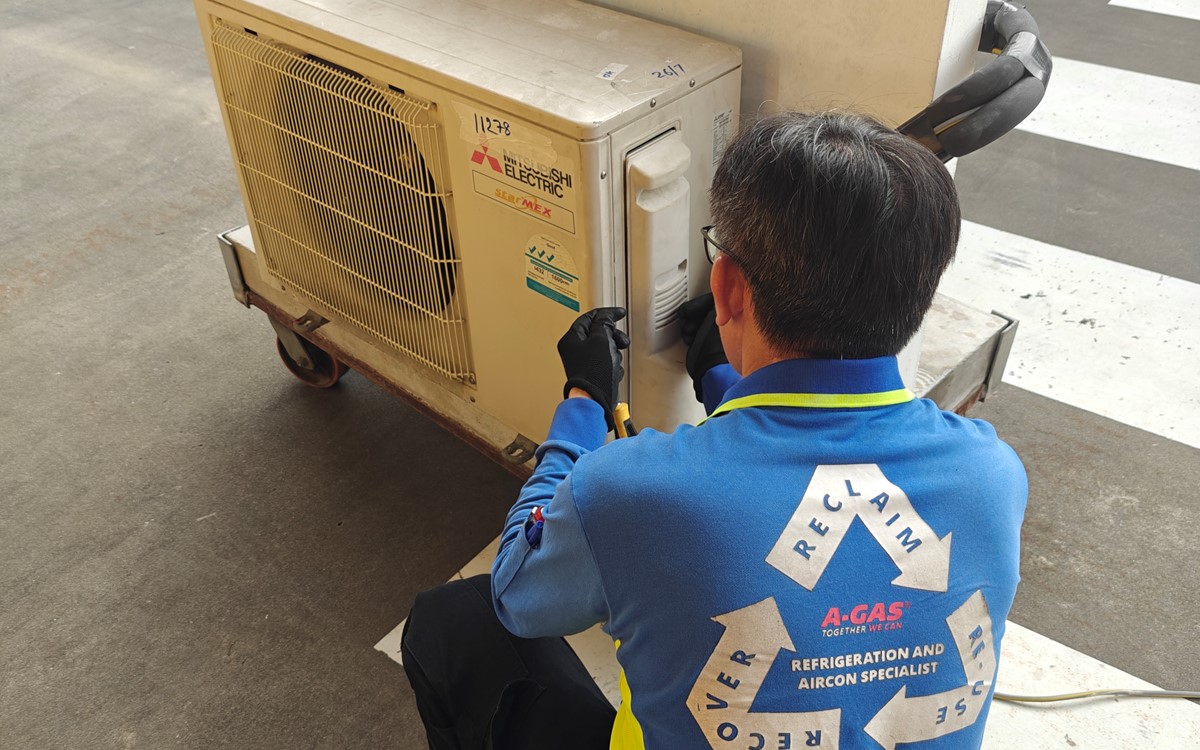 A man works with an air conditioning system outside