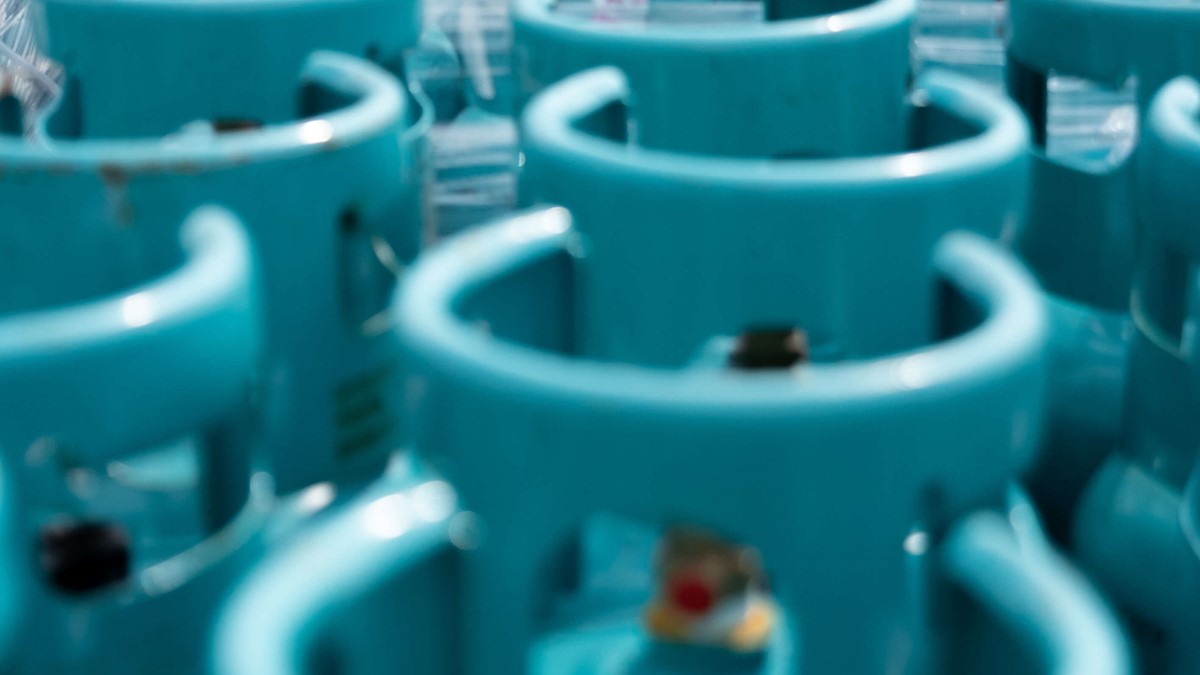 Rows of cylinders with blue tops in a warehouse