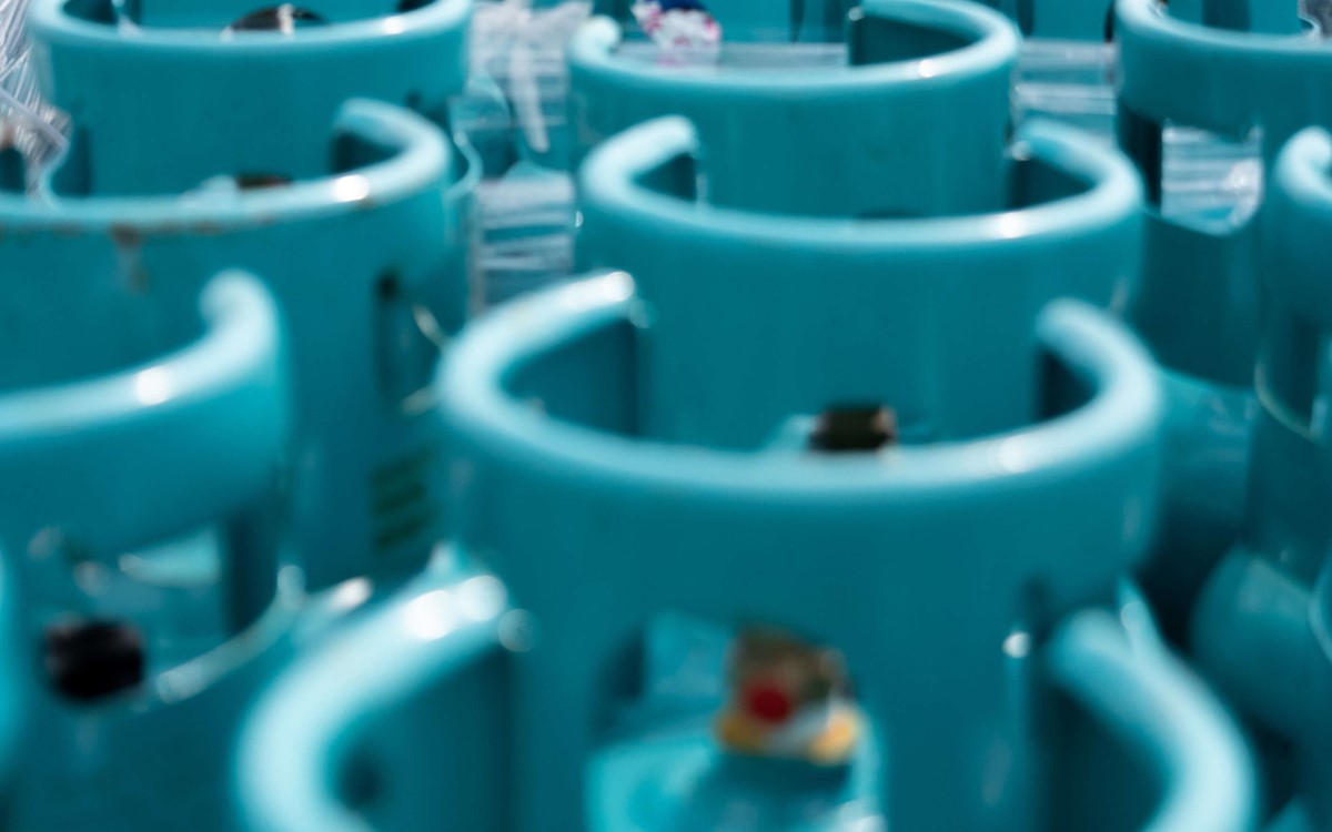 Rows of cylinders with blue tops in a warehouse