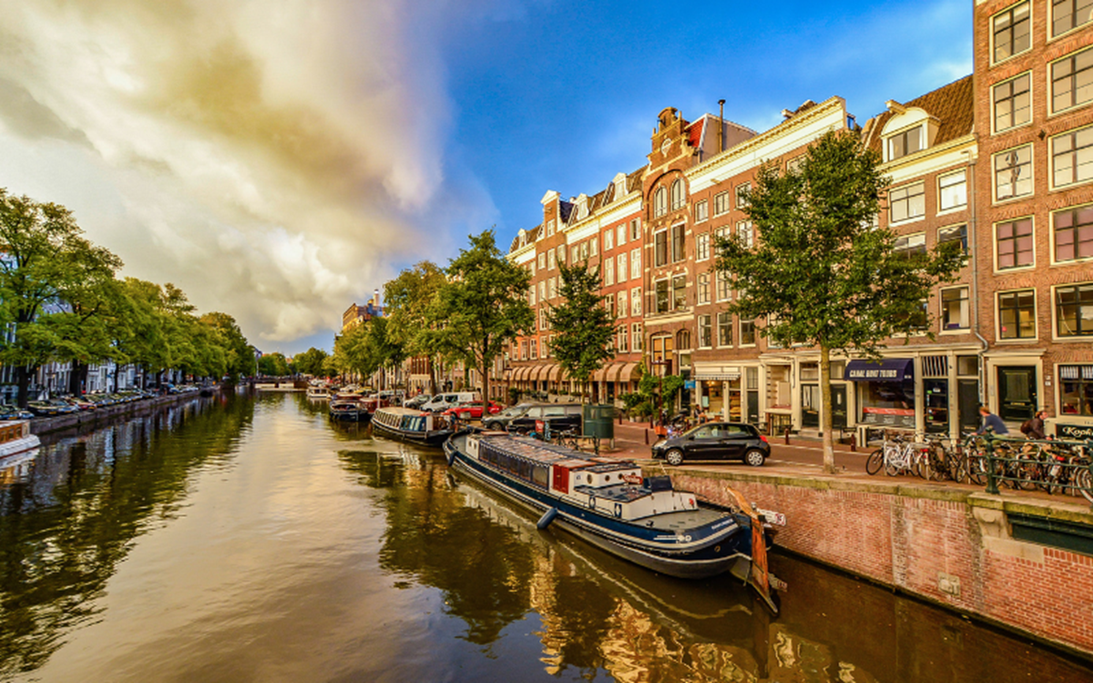 A river with buildings on each side and canal boats