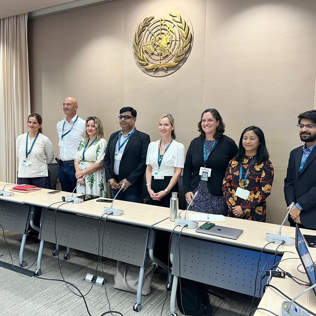 A group of people standing and smiling in a conference room