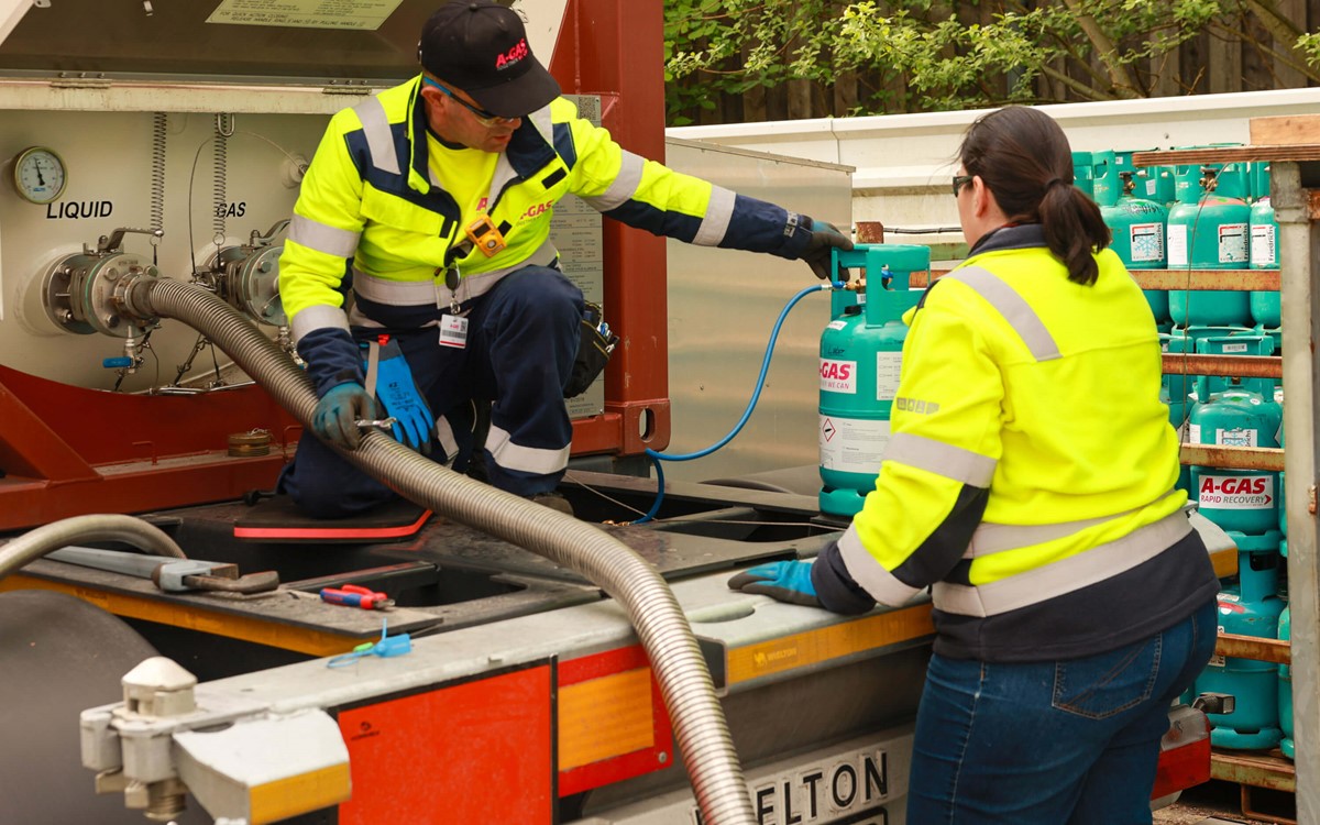 A man and a woman in yellow high-vis jackets working on-site