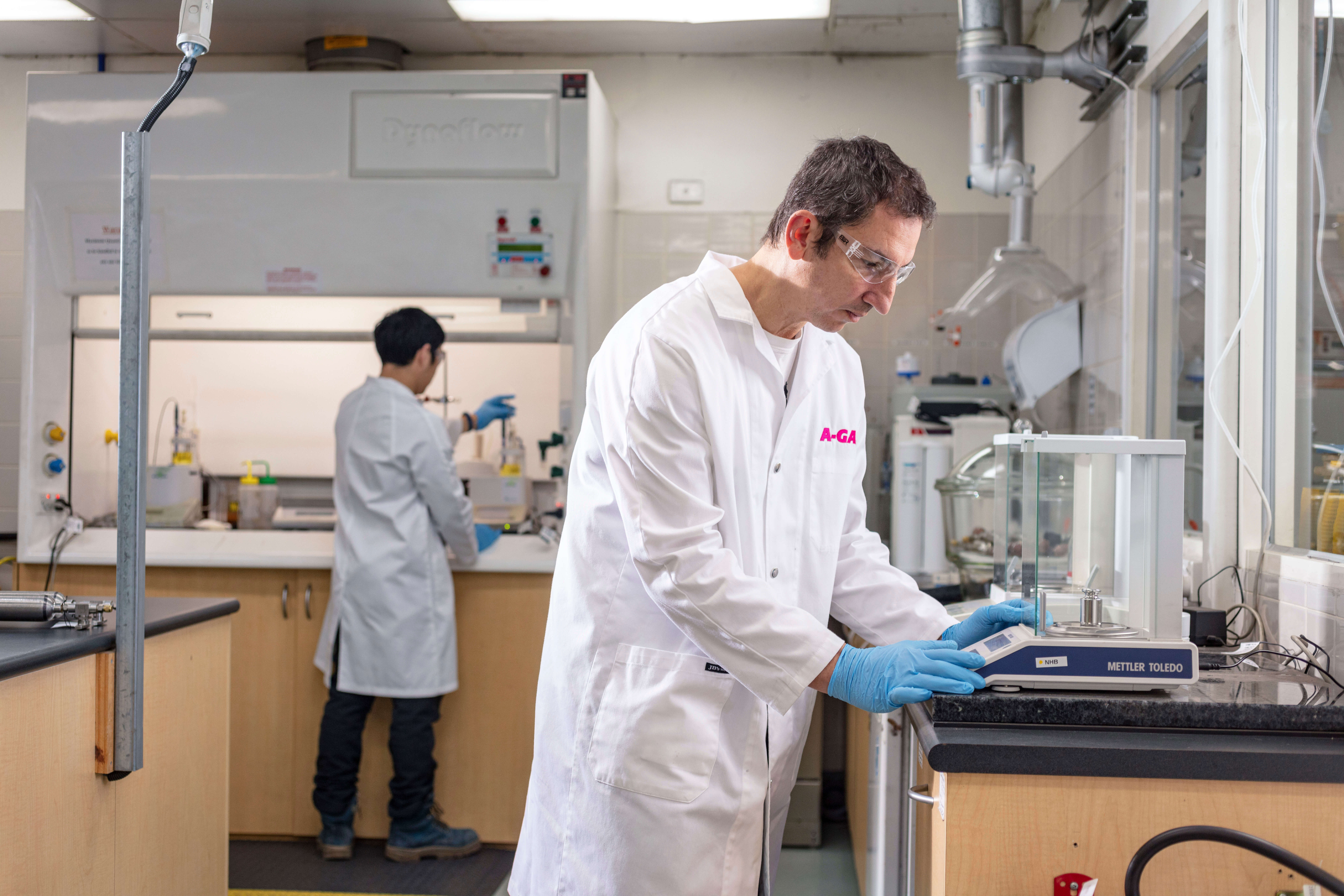 Two men in white coats working with laboratory equipment 