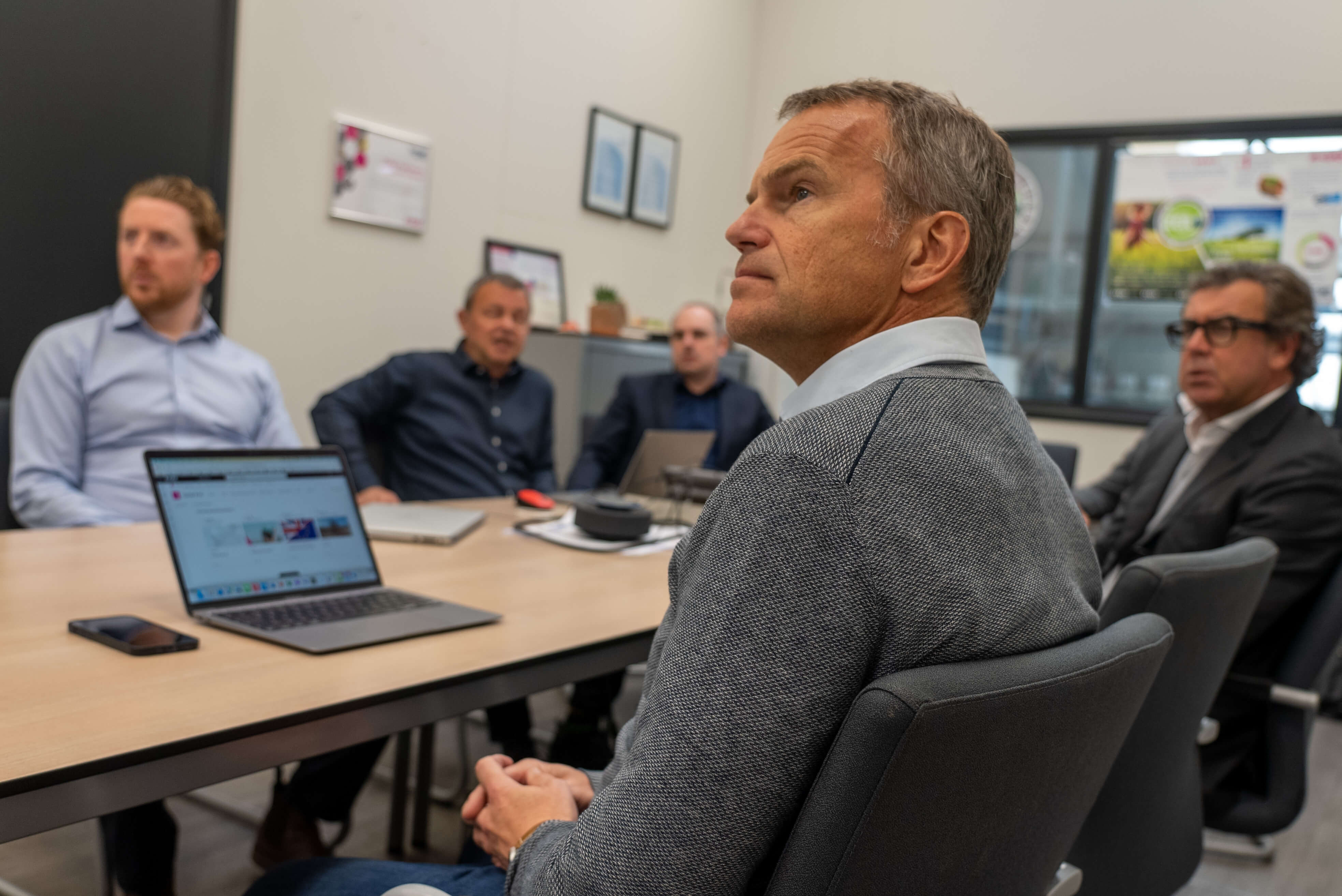Five men in an office attending a meeting 