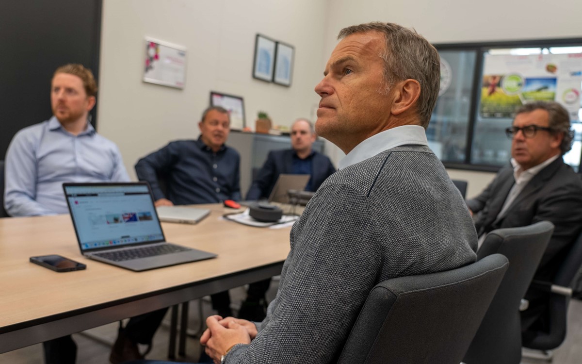 Five men in an office attending a meeting