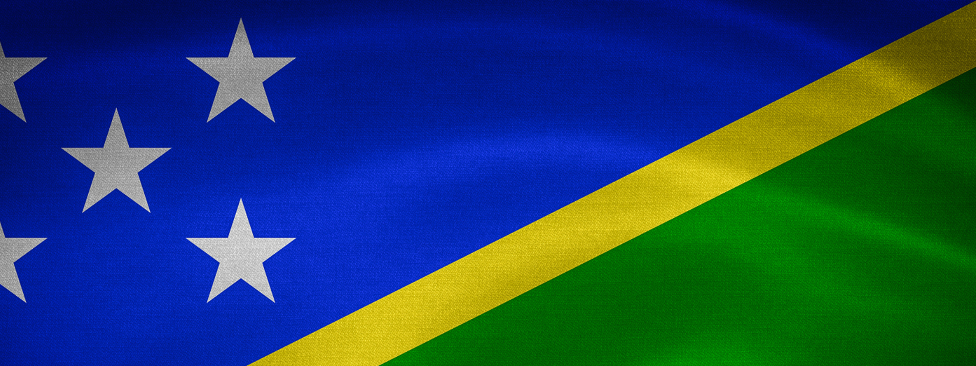 The blue, yellow and green flag of the Solomon Islands with white stars in the top left corner