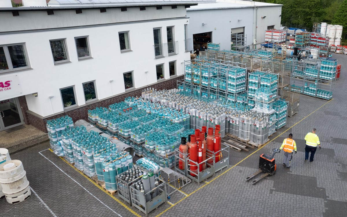 Two people walking through a site with cylinders from above