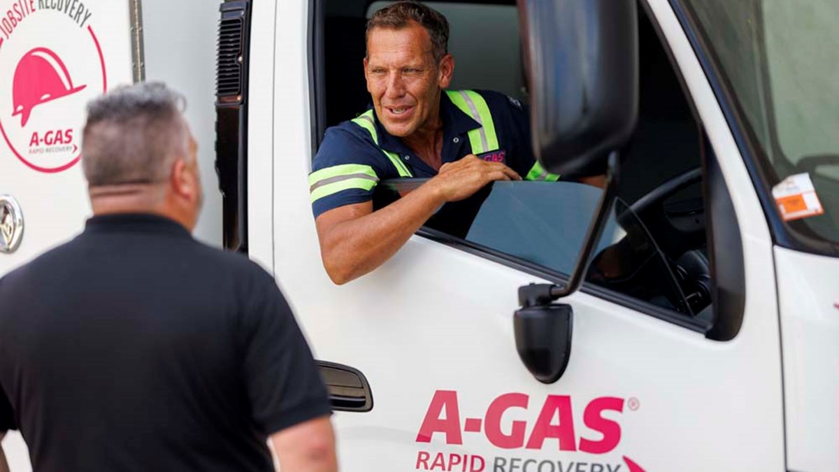 Two men talking through the window of a white van