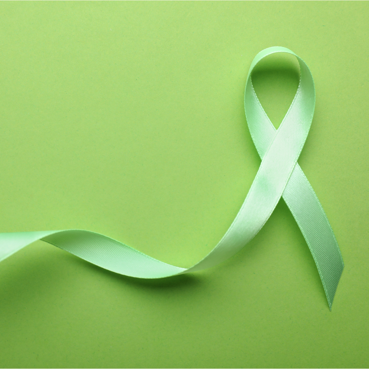 A tile featuring a green ribbon against a light green backdrop