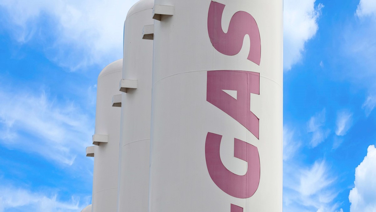 Four white separation towers with pink A-Gas logo outside a building