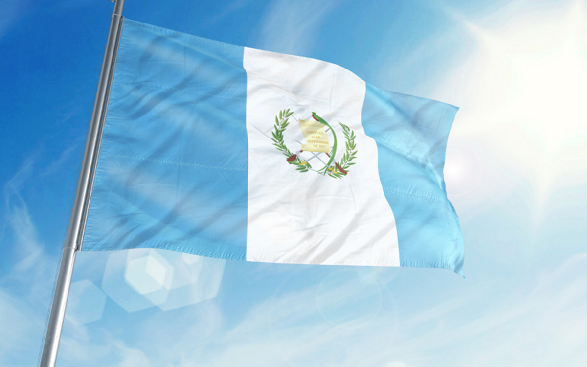 A close-up of the light blue and white Guatemala flag with blue sky in the background