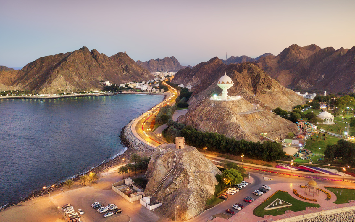 A picture of mountains next to the sea with buildings