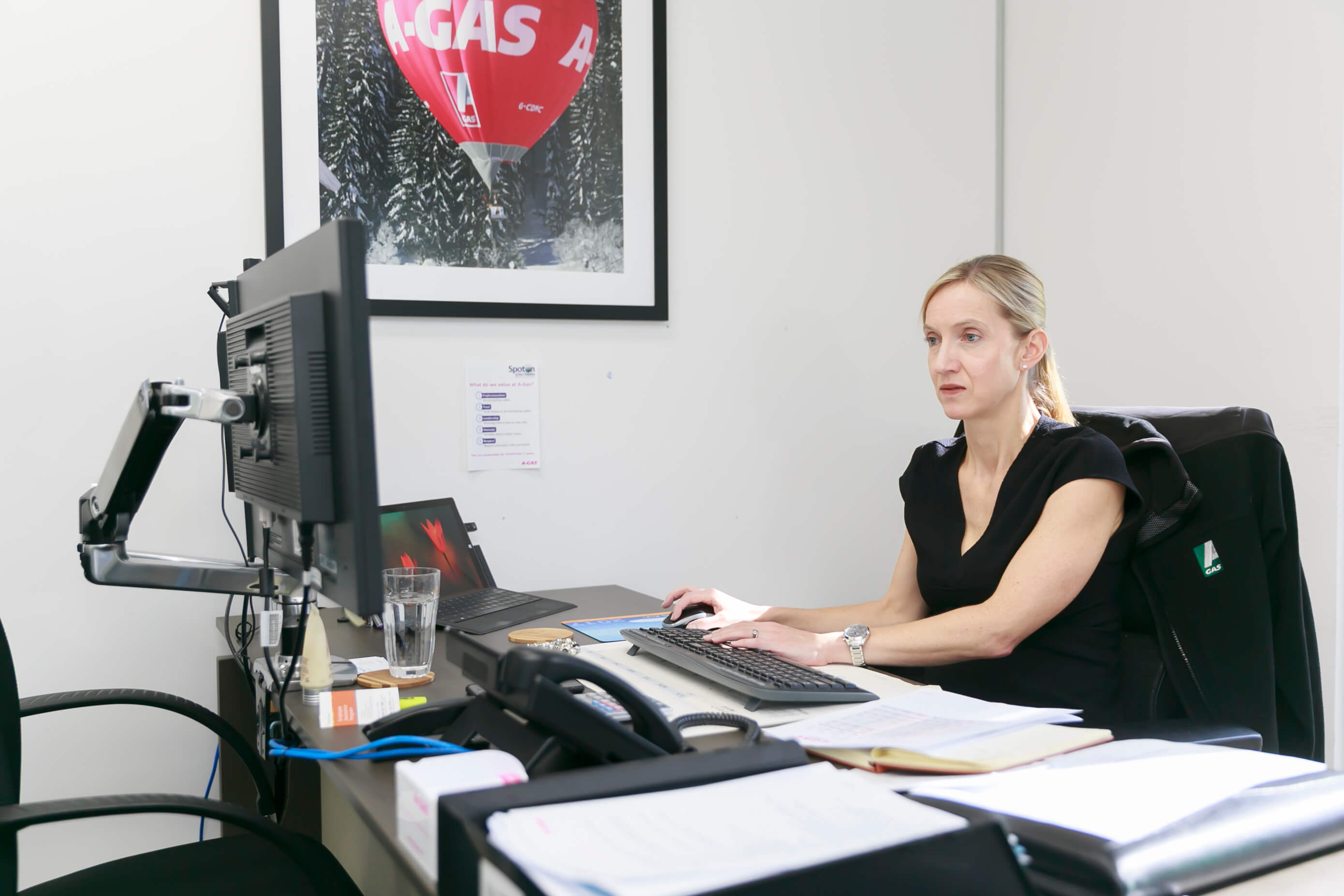 A woman sat at her desk using the computer