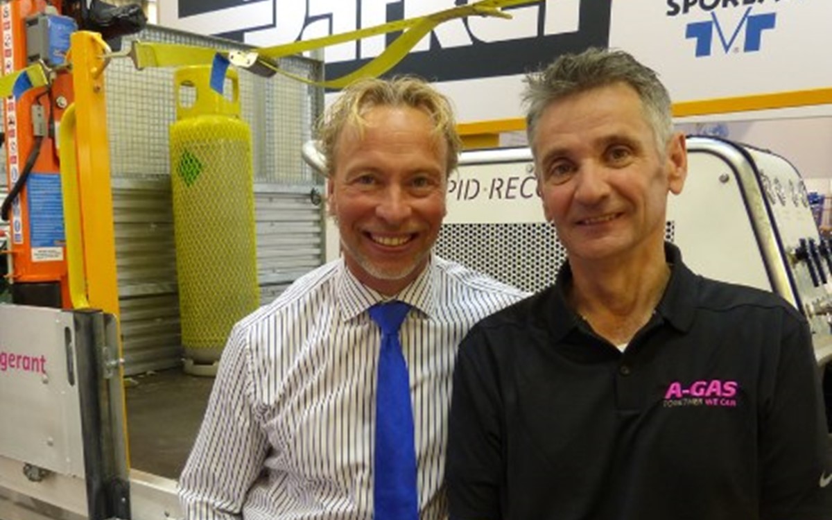 Two men stand in front of a white A-Gas truck and smile at the camera