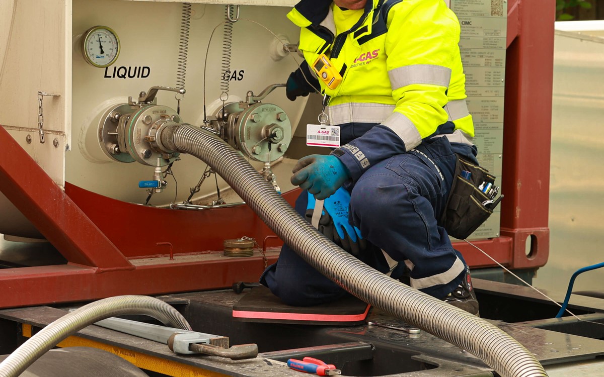 Man in a yellow high-vis jacket working with machinery on-site