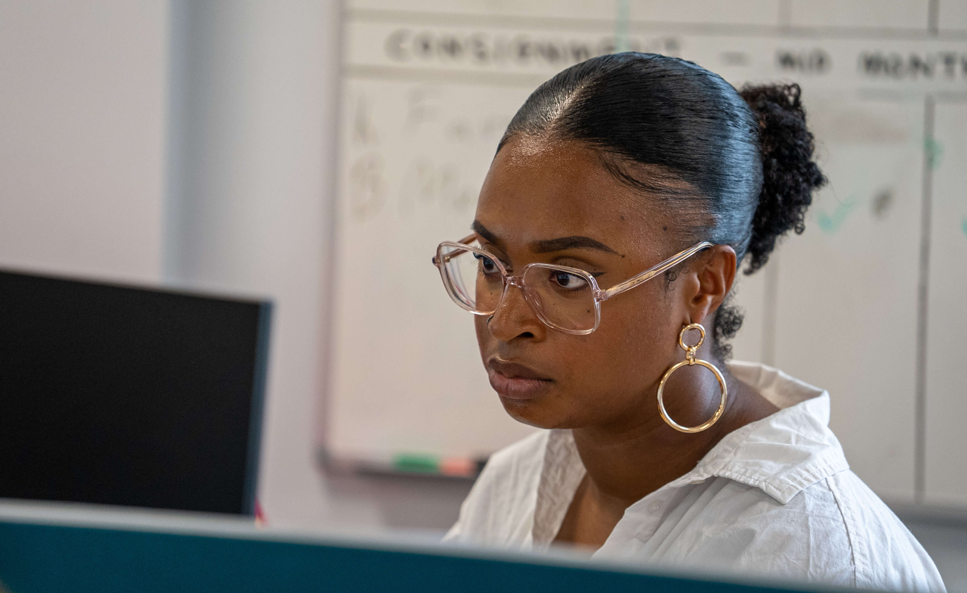A woman wearing glasses working at a computer 