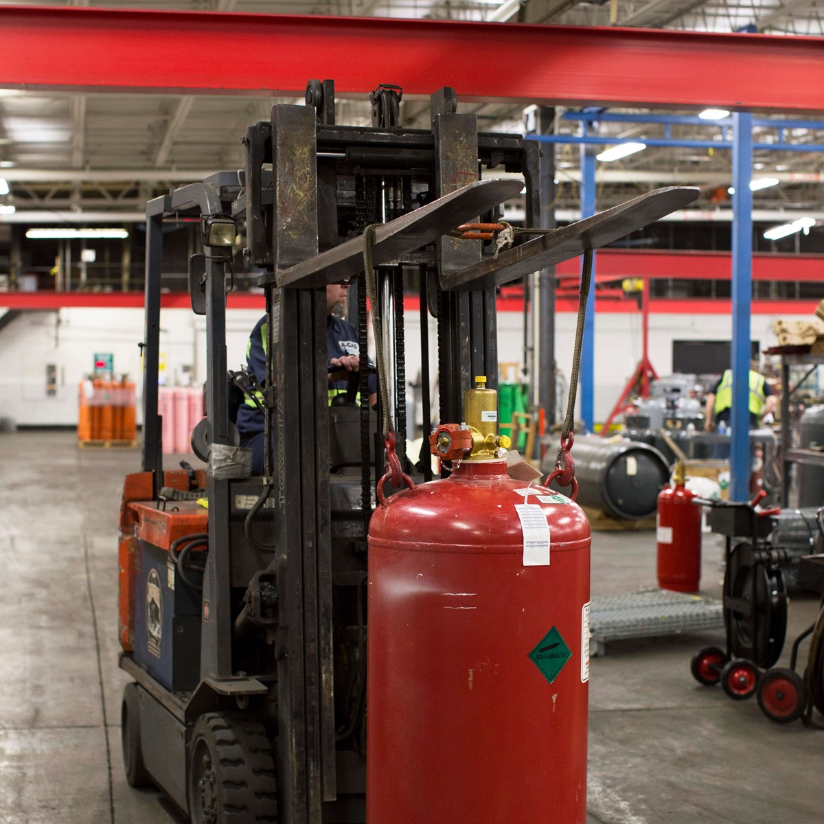A forklift truck moving a cylinder around a warehouse
