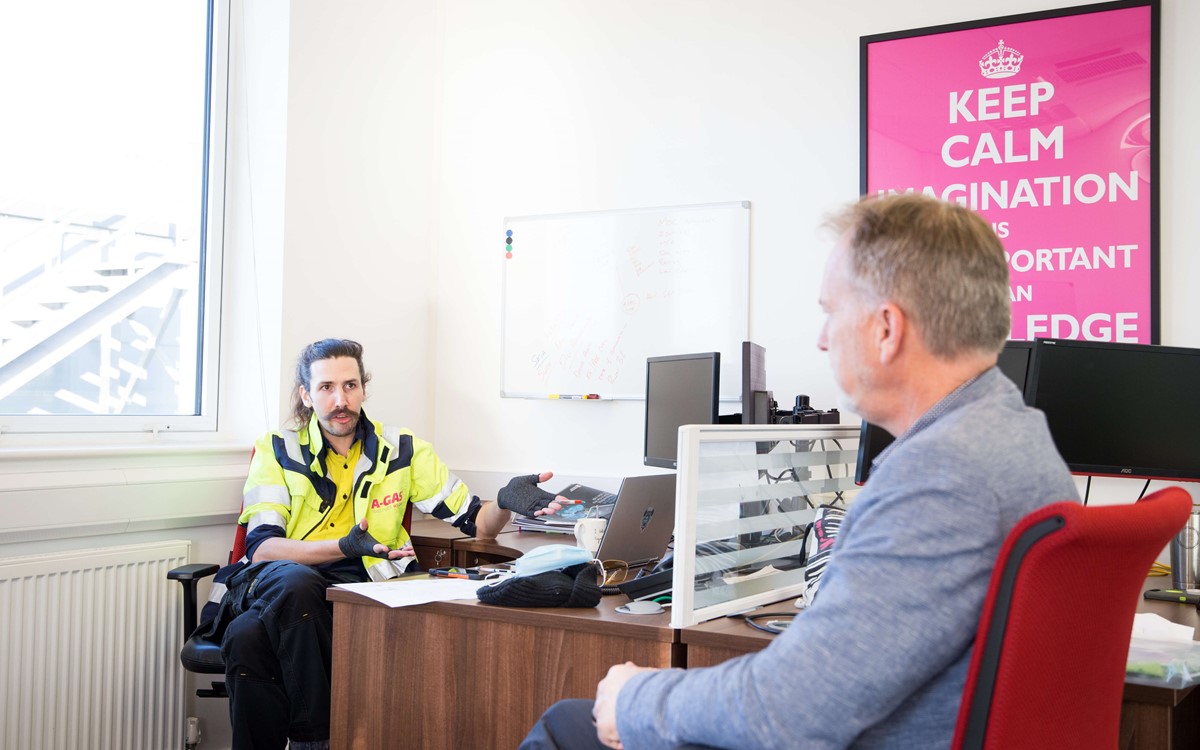 engineer and office worker talking at their desk