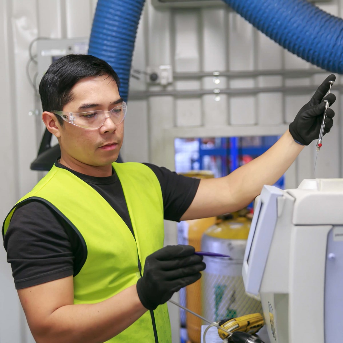 Worker carrying out laboratory analysis on refrigerant gas