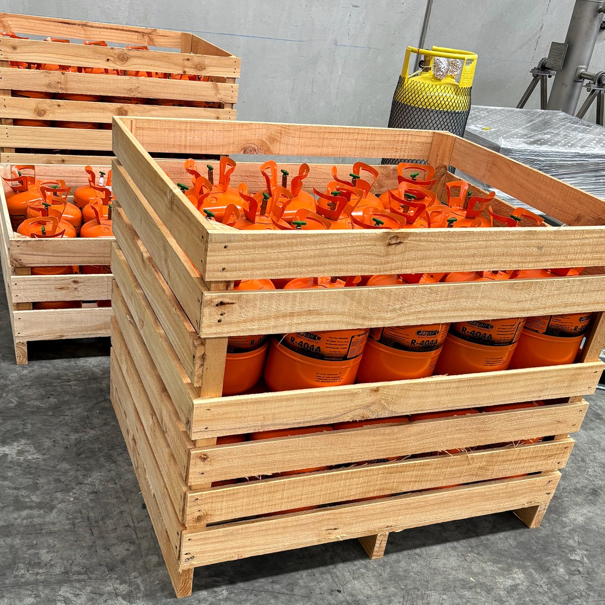 Orange cylinders stacked in a wooden crate in a warehouse