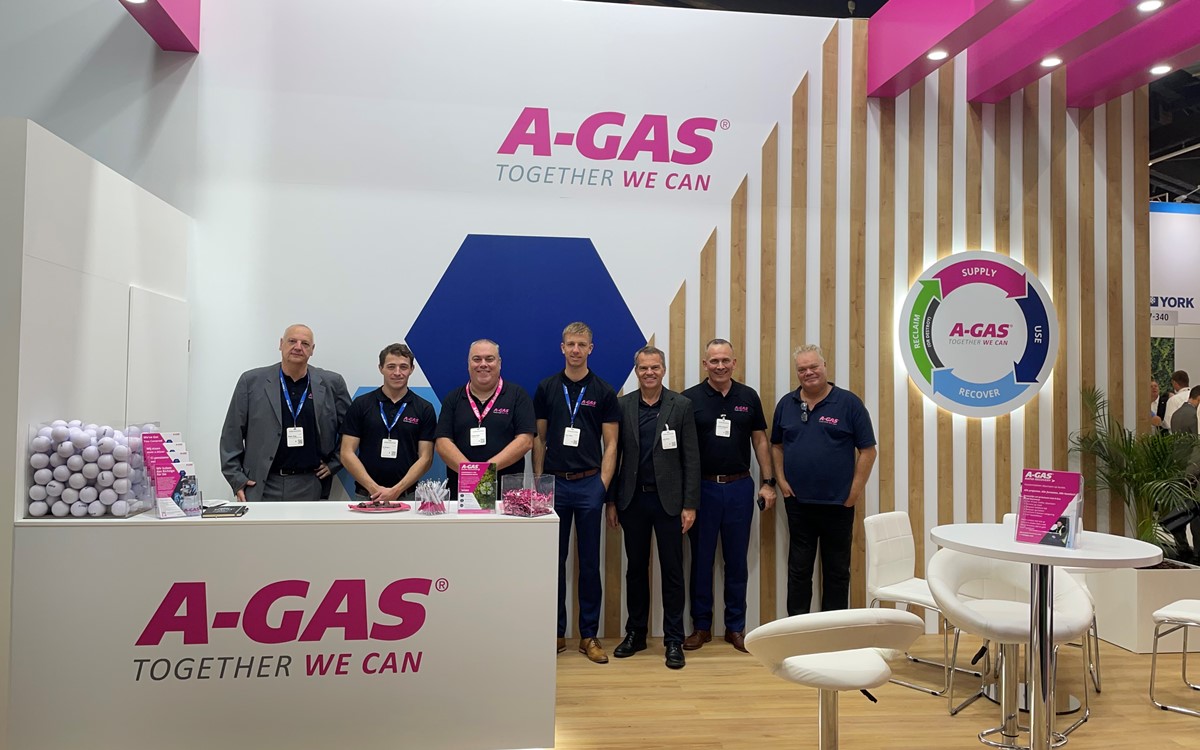 A group of men standing at an A-Gas stall in a tradeshow hall