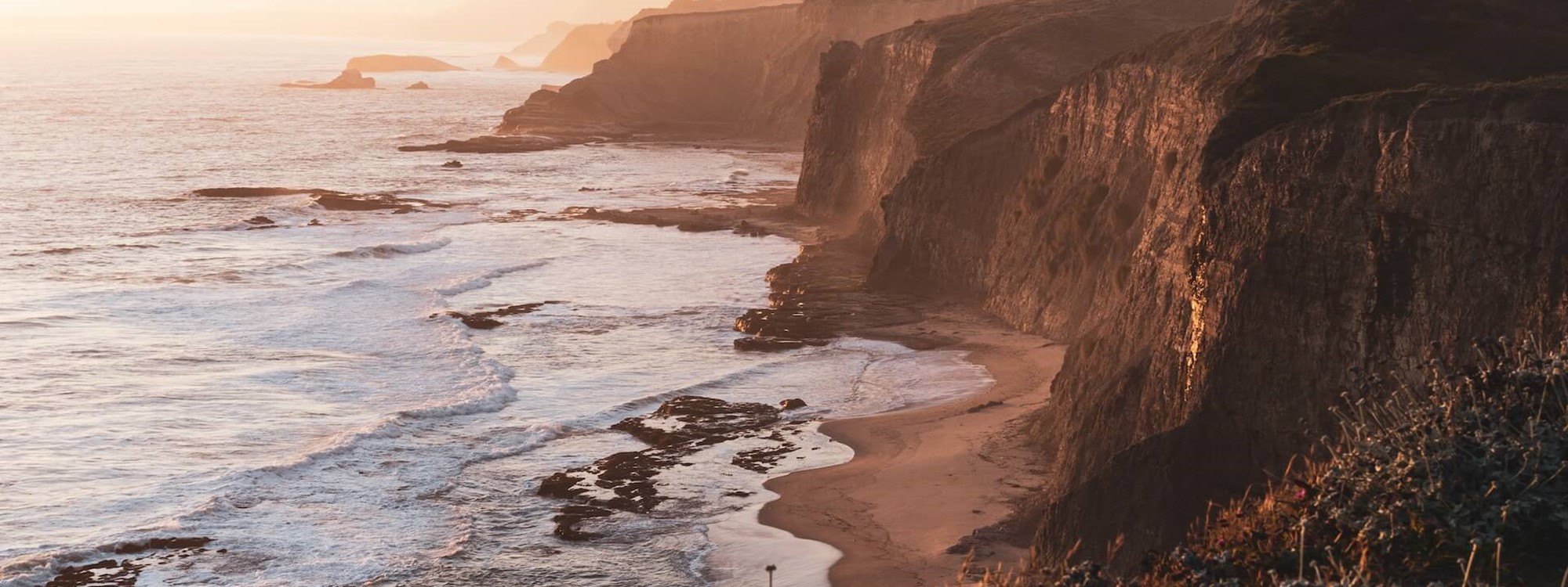 A photo of Californian coastal cliffs at sunset.