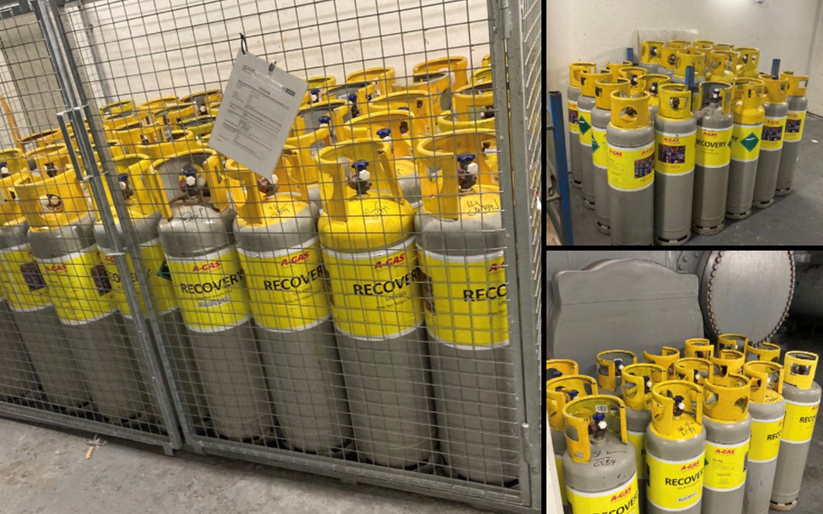 Rows of large grey cylinders with yellow tops in metal caging