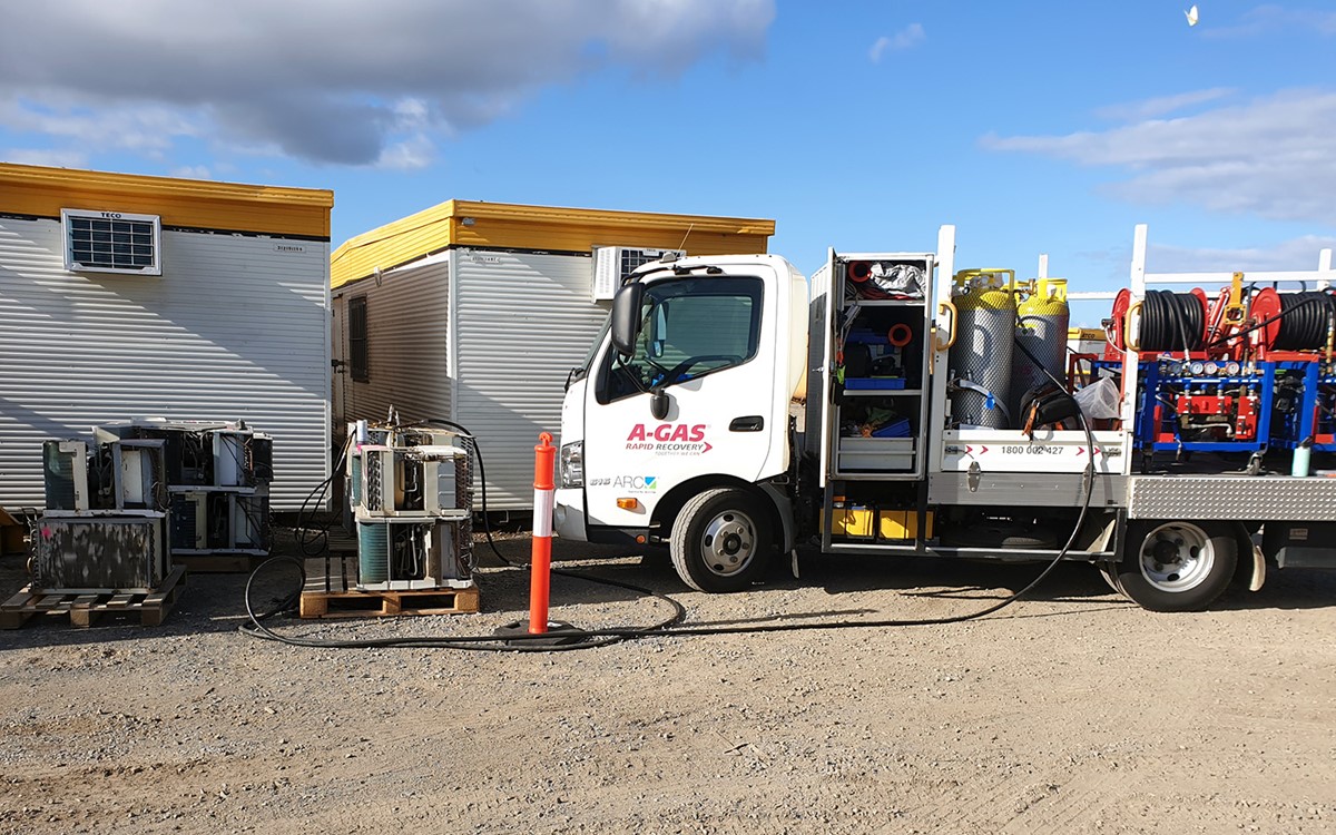 Wide shot of white van with refrigerant equipment outside