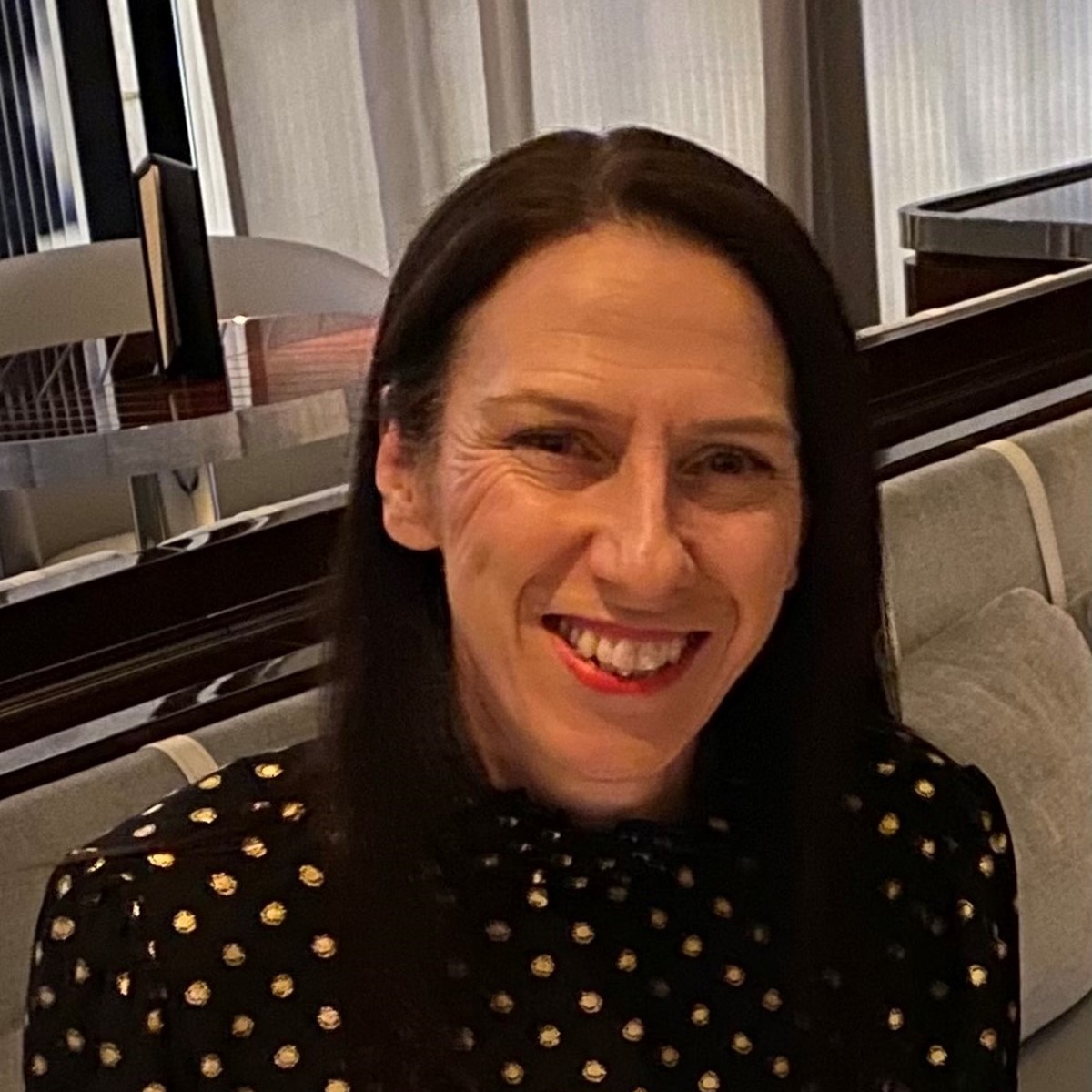 A headshot of a woman smiling in a casual setting