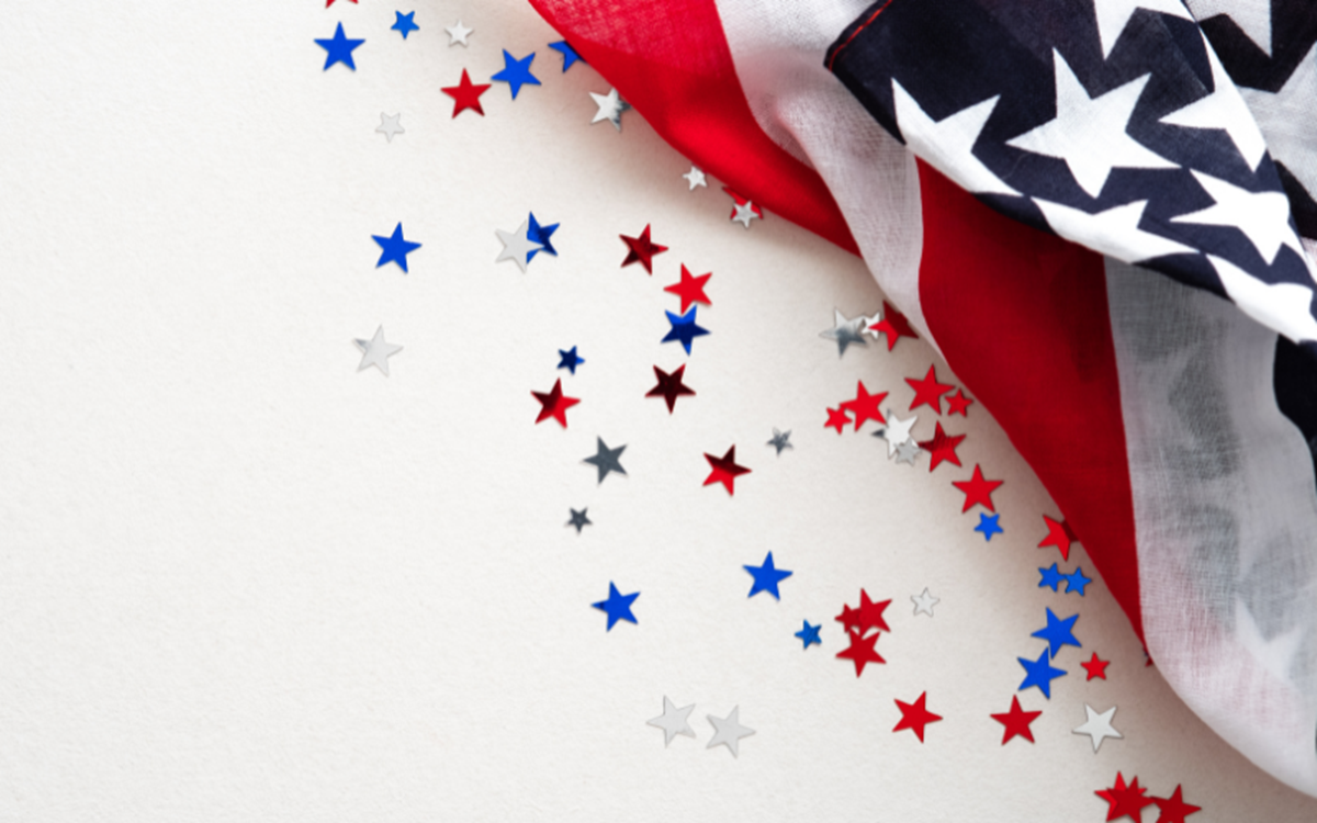 A graphic with an unfurling USA flag surrounded by red, white and blue stars