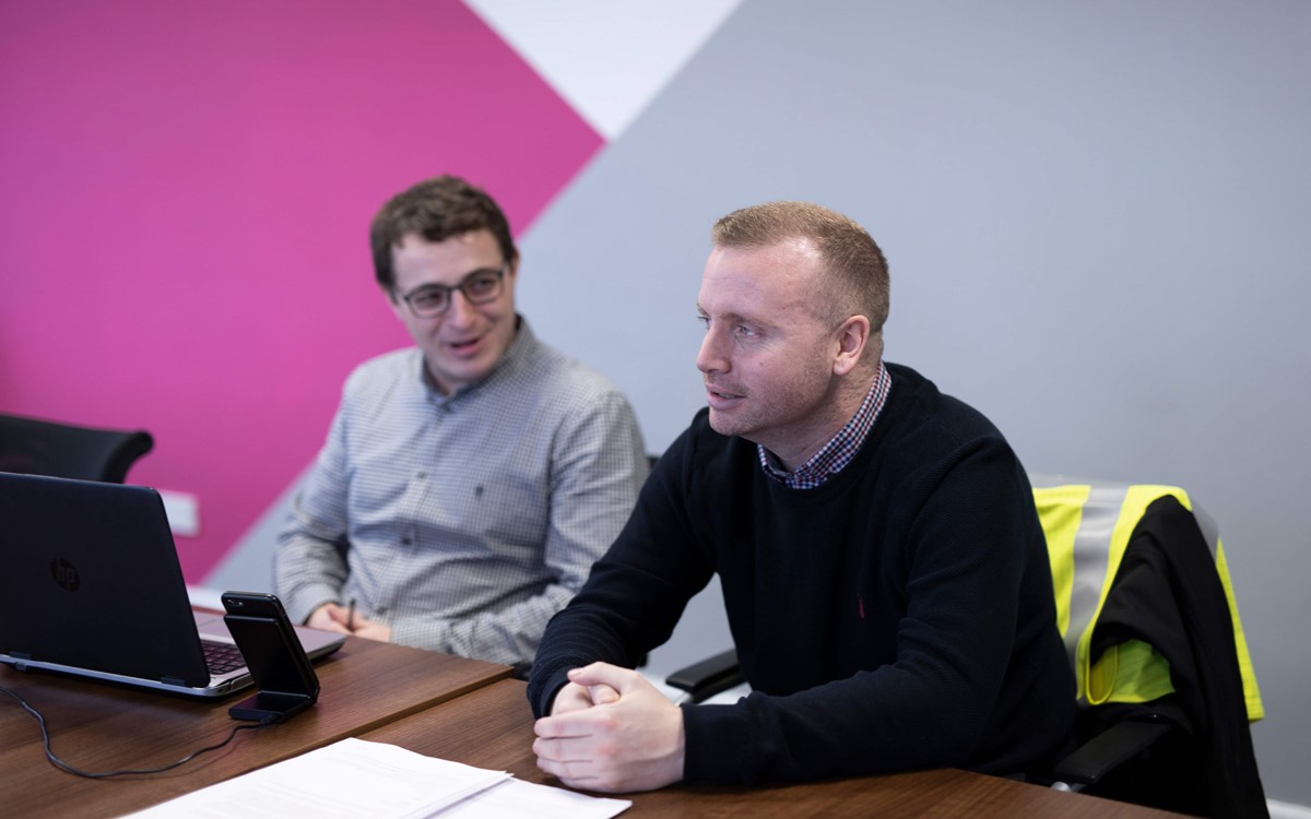 Two men sat at a desk in a meeting
