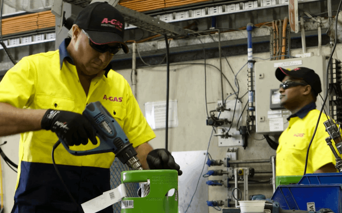 Two warehouse workers with cylinders in a warehouse