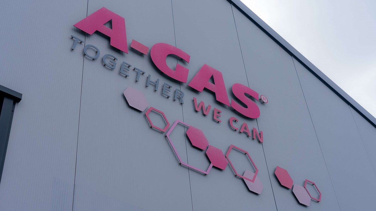 The pink A-Gas logo on the side of a building from below