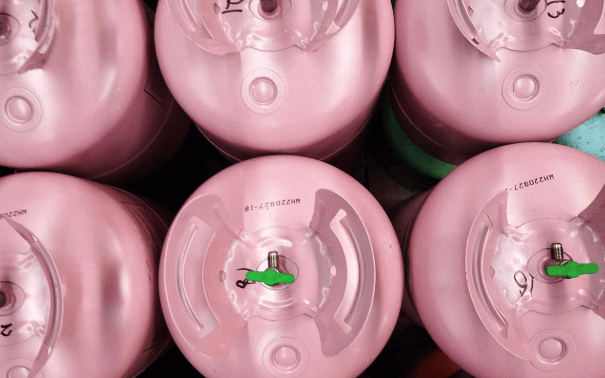 Rows of pink disposable cylinders with green valves from above