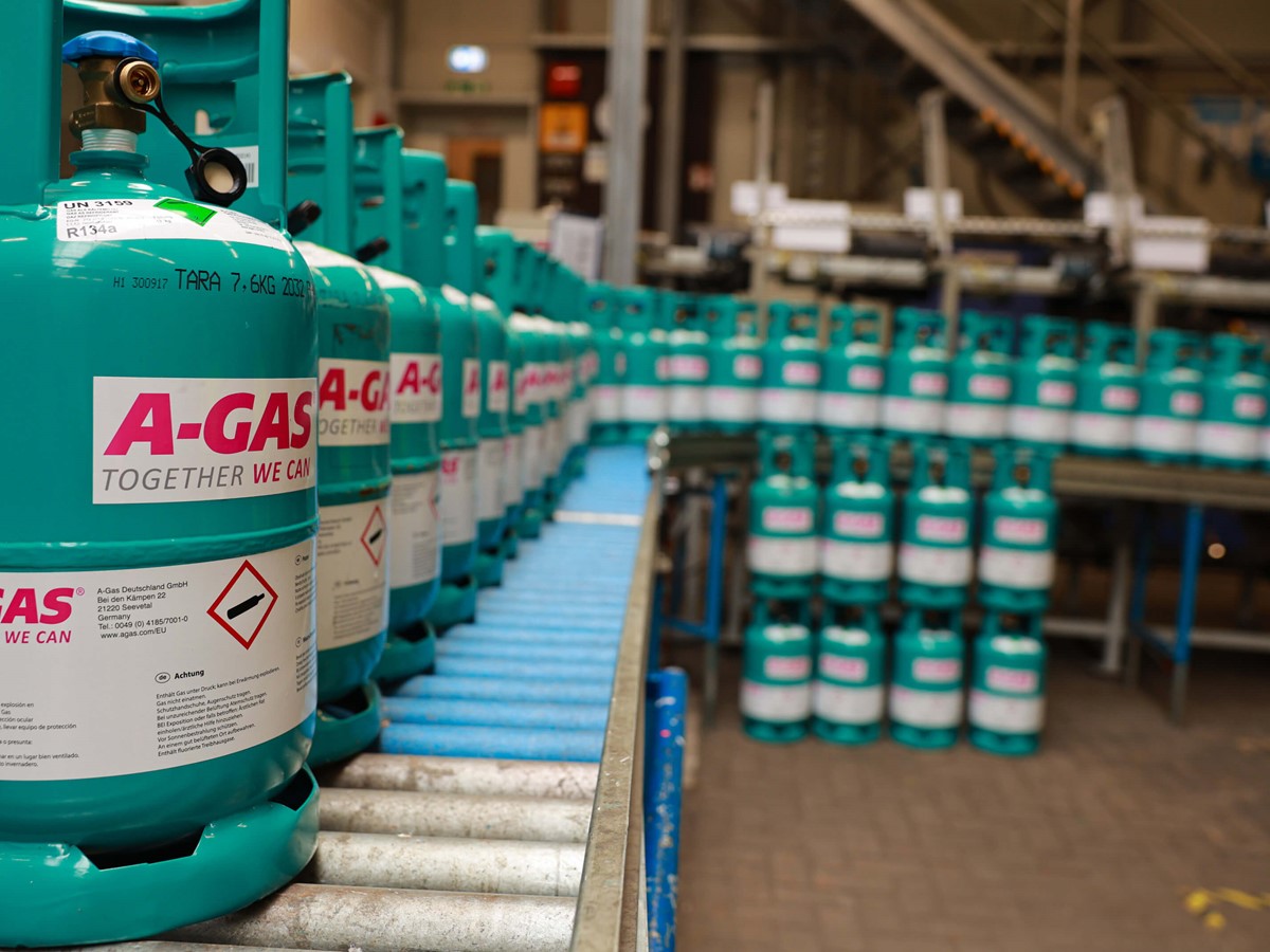 Wide shot of blue cylinders on a conveyor belt in a warehouse