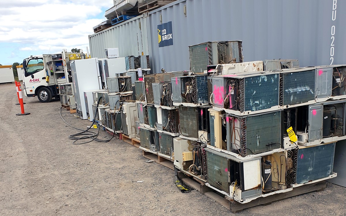 Disused air conditioning equipment stacked against a metal container