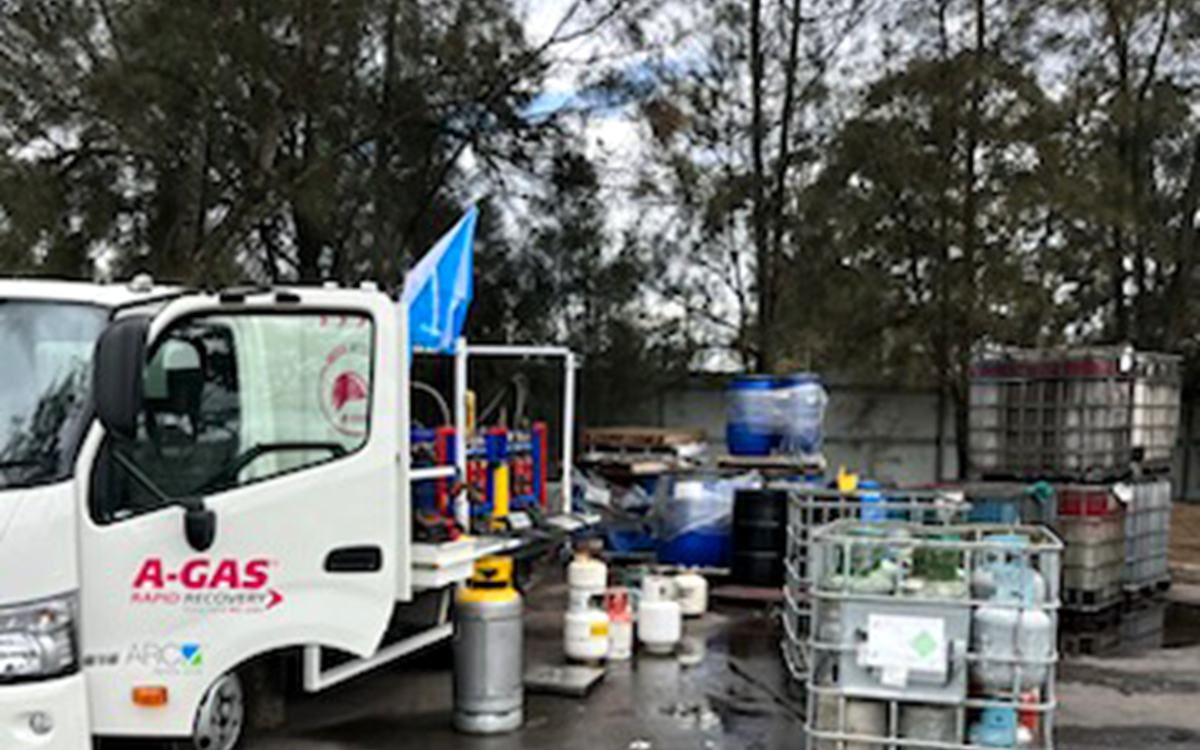 White van in yard next to gas cylinders