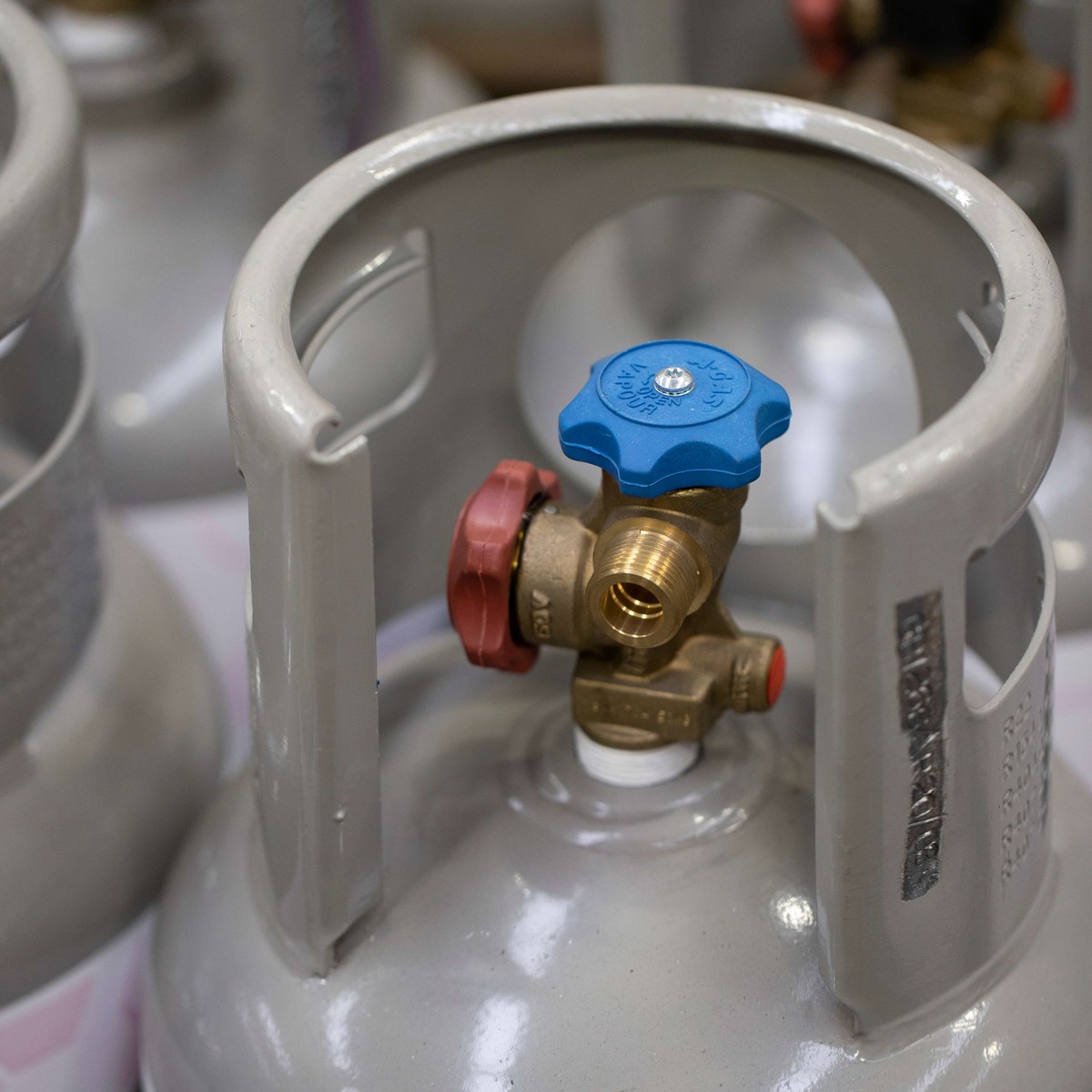 close up of grey cylinder with blue valve head