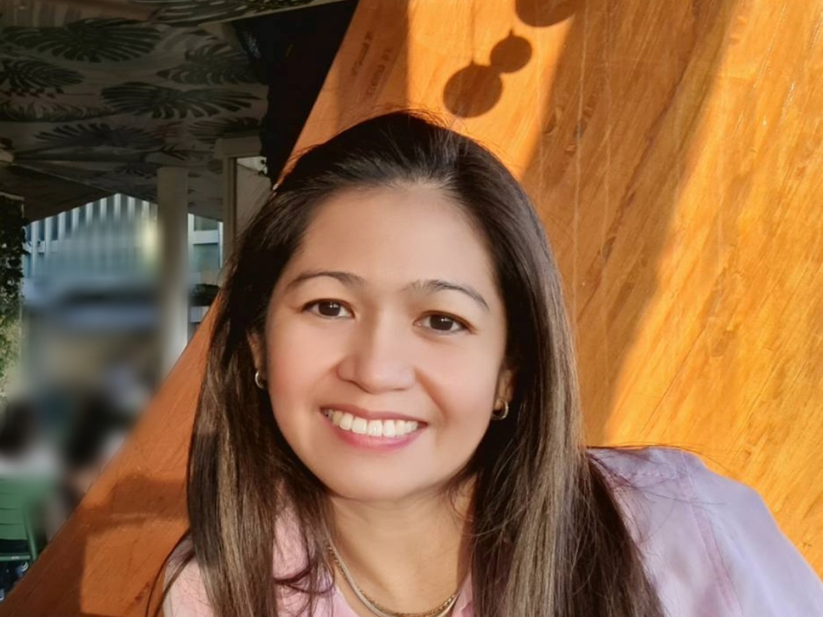 A headshot of a woman in a pink shirt smiling