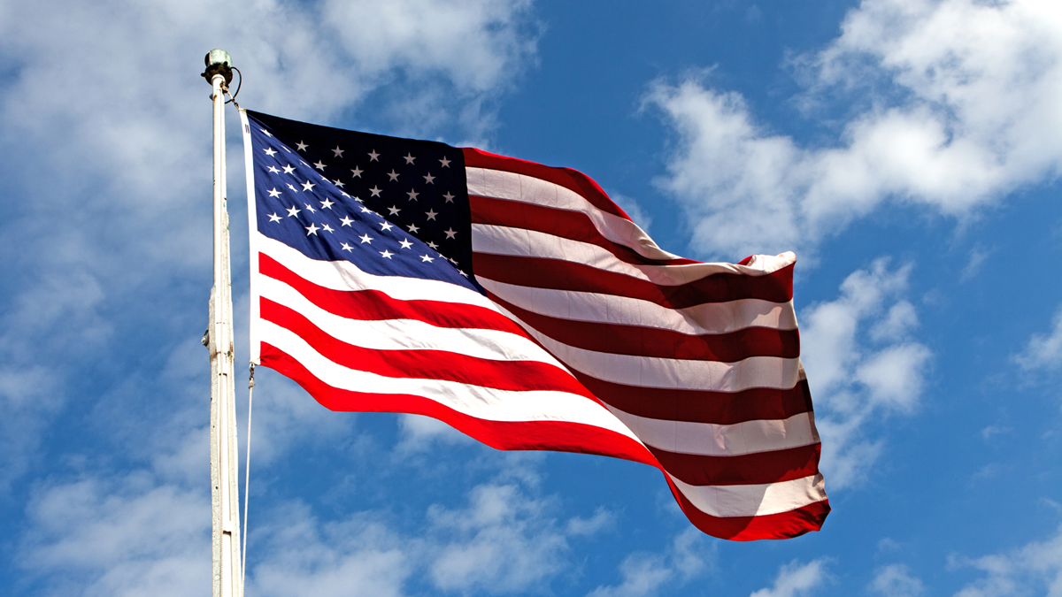 A picture of the USA flag on a pole outside taken from below
